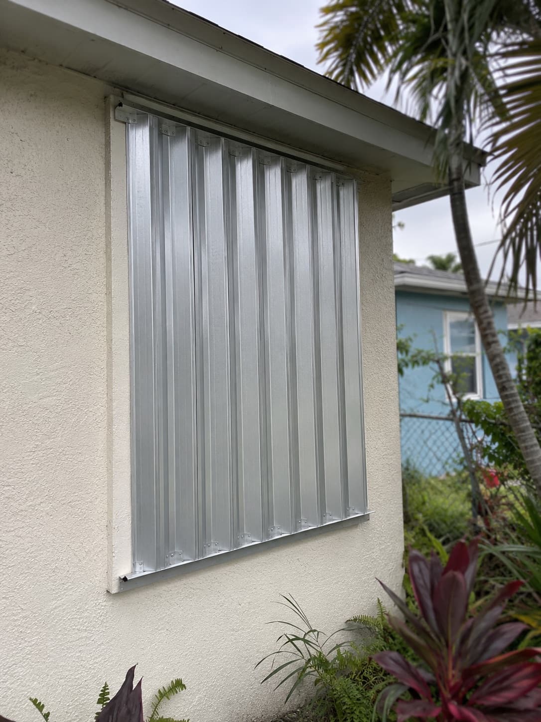 An aluminum storm panel installed over a window on a Florida home.